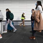 People walking with suitcases.