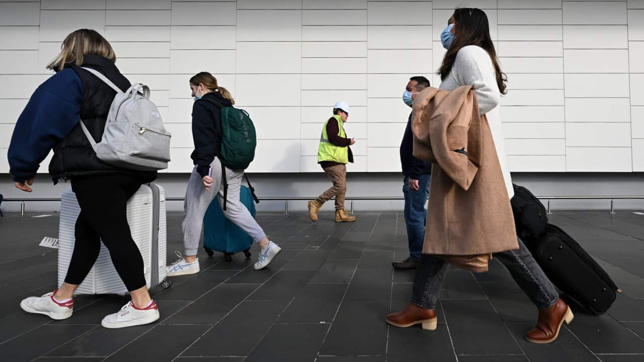 People walking with suitcases.