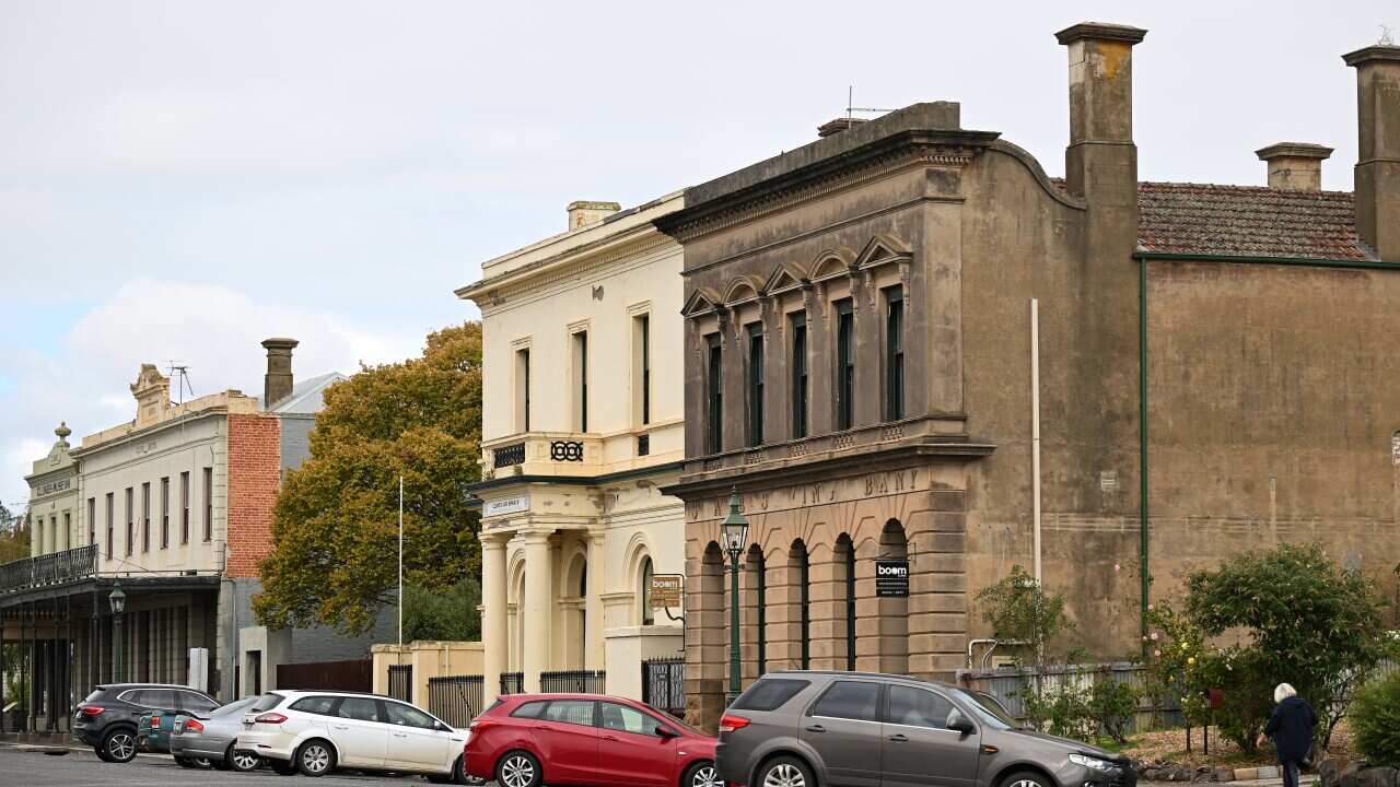 A block of houses with cars parked in front.