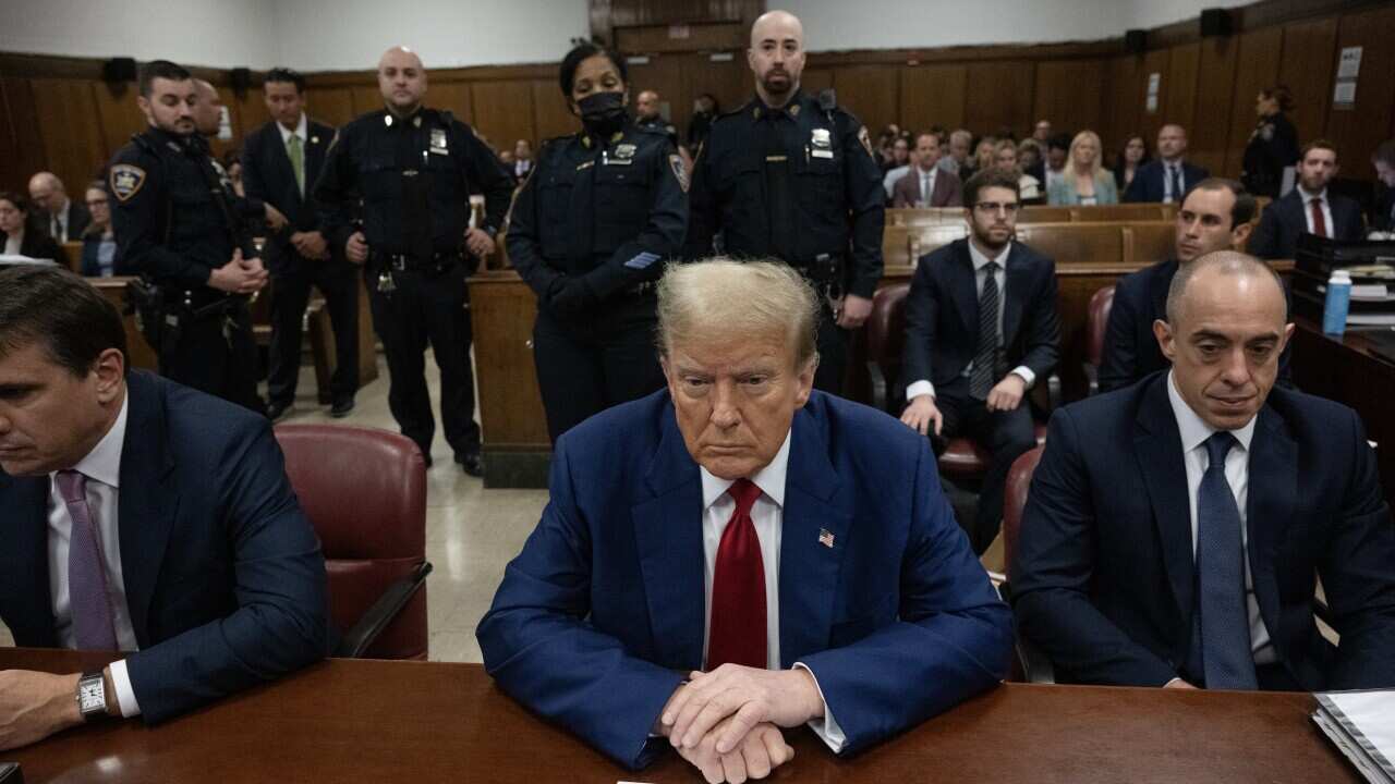 A man wearing a suit sitting in a courtroom