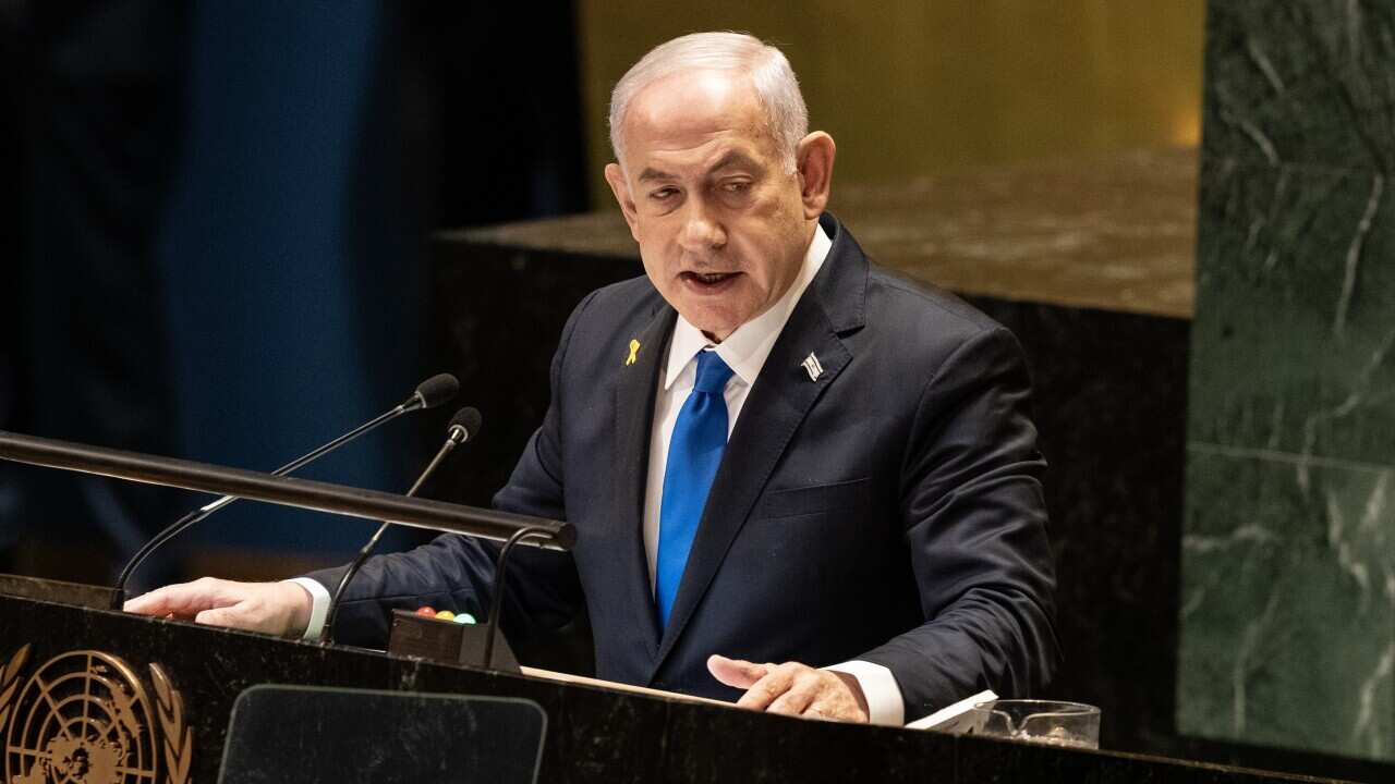 A man speaks at a lectern.