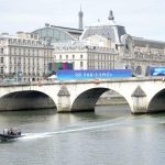 The Seine River and a bridge with Paris 2024 banners on it.