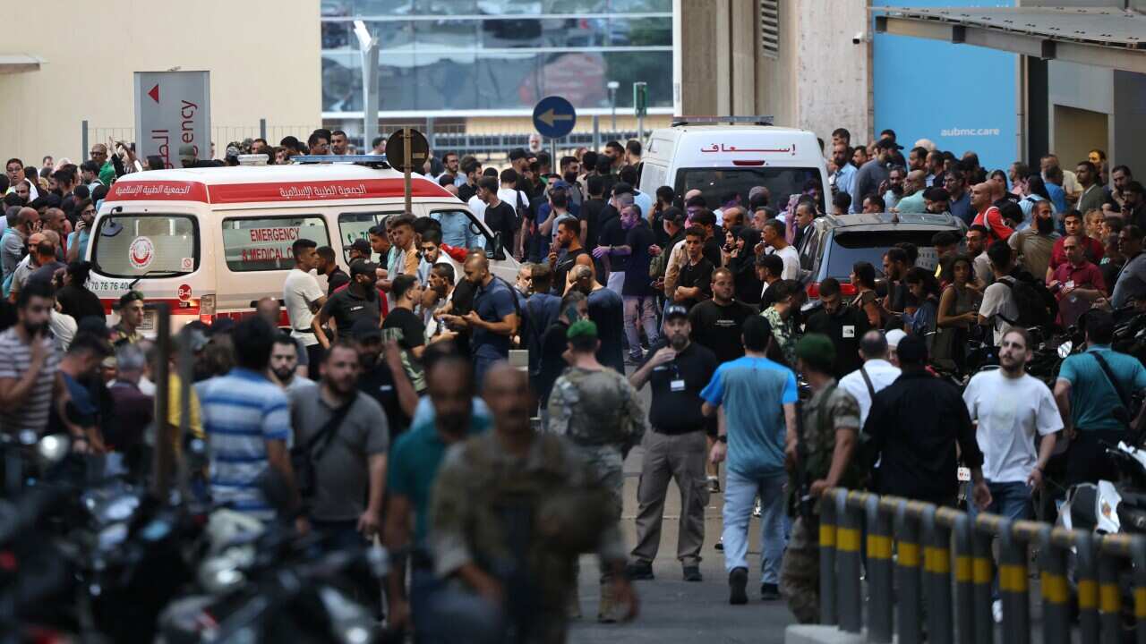 Crowds of people on the streets, with ambulances driving around them tending to the injured.